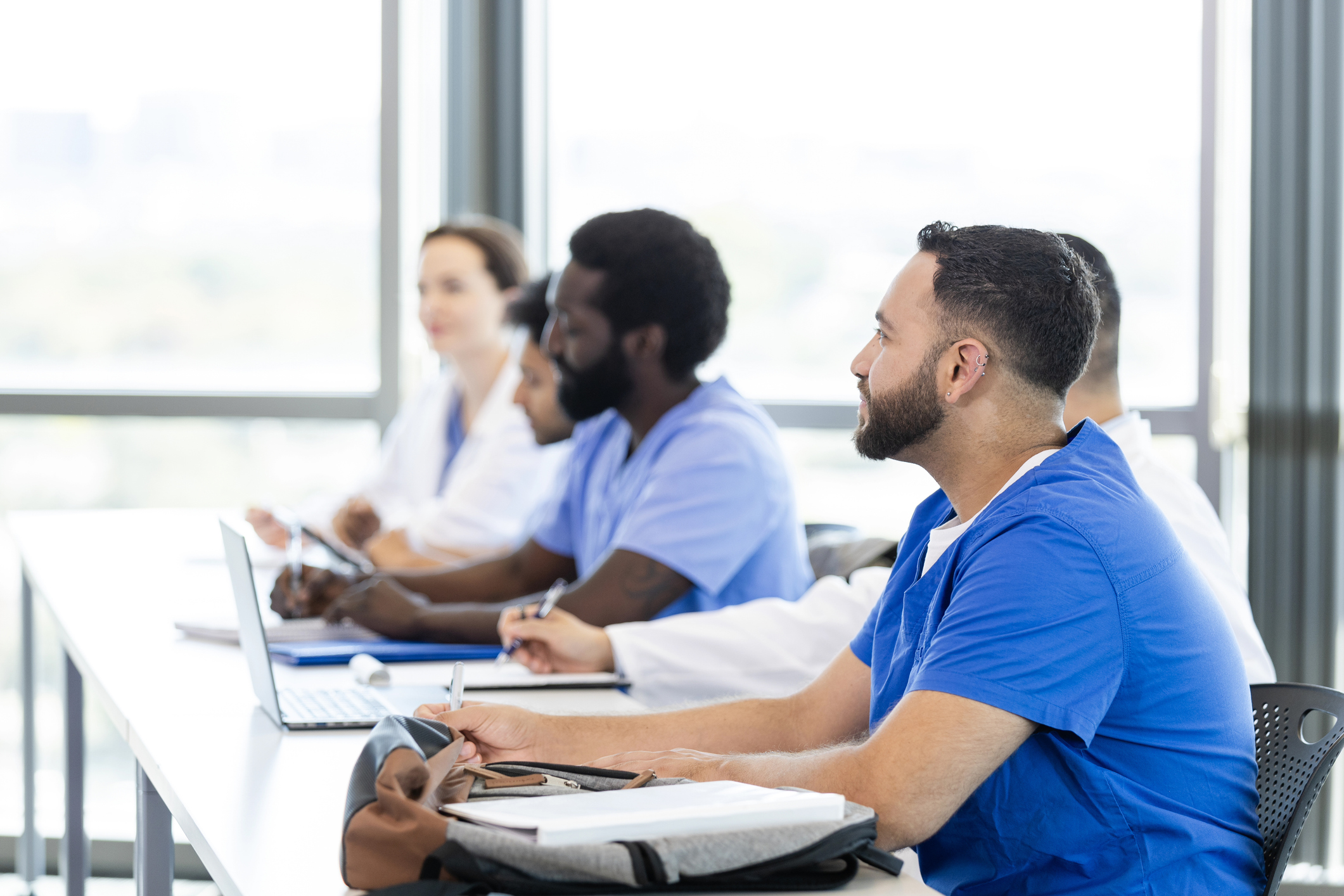 Teilnehmende einer medizinischen Fortbildung sitzen im Schulungsraum und verfolgen aufmerksam den Unterricht